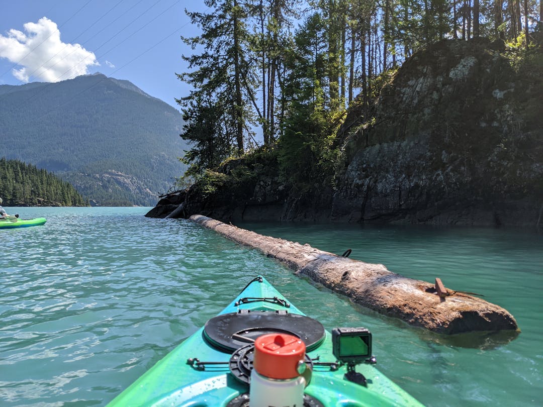 A kayak on a lake, next to a small rocky island beach